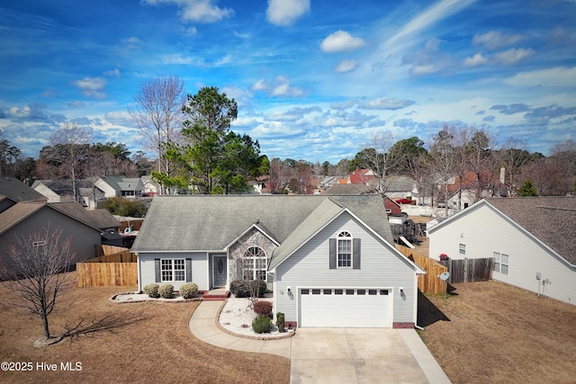 traditional home with driveway, an attached garage, fence, and a front yard