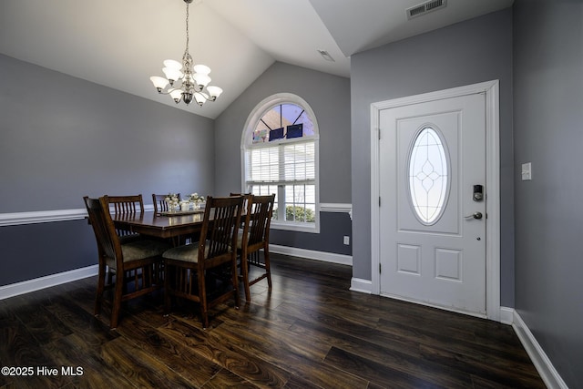 dining area with lofted ceiling, visible vents, dark wood finished floors, and an inviting chandelier