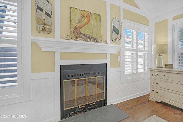 interior space featuring wood finished floors and a glass covered fireplace