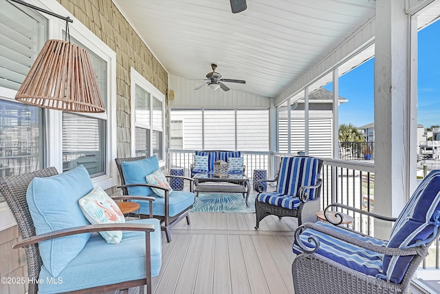 sunroom with lofted ceiling and a ceiling fan