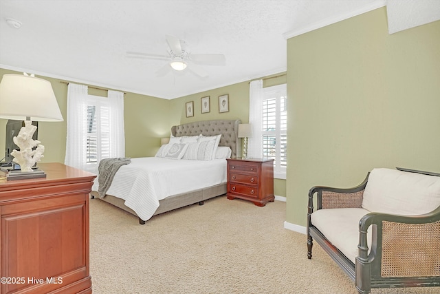 bedroom with ceiling fan, a textured ceiling, light colored carpet, baseboards, and ornamental molding