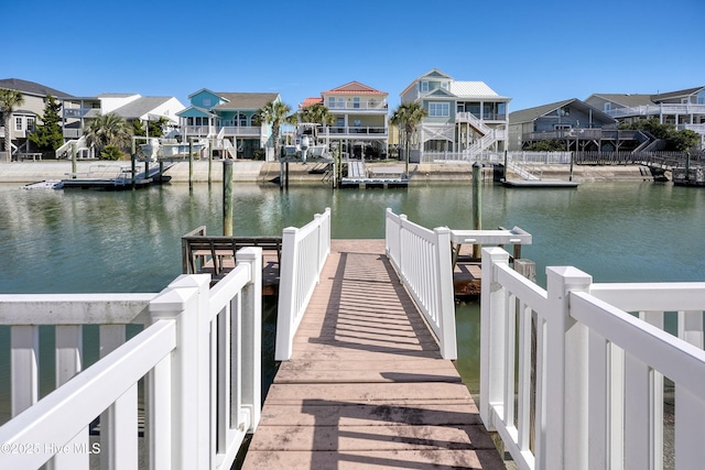 view of dock with a residential view and a water view