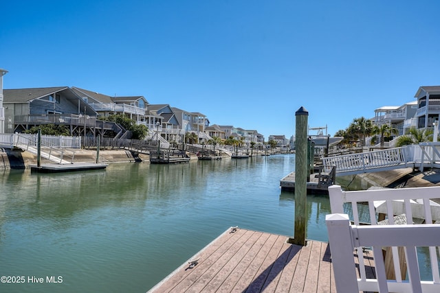 view of dock with a residential view and a water view