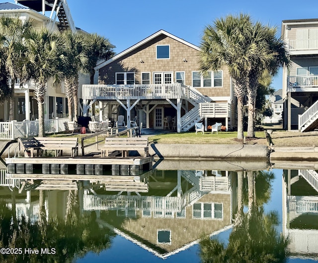 rear view of property featuring a water view and stairway