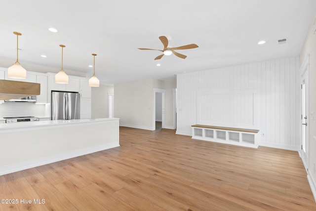 unfurnished living room featuring recessed lighting, visible vents, baseboards, a ceiling fan, and light wood-type flooring