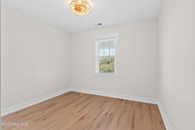 unfurnished room with visible vents, baseboards, and wood finished floors