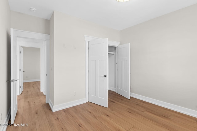 unfurnished bedroom with light wood-type flooring and baseboards