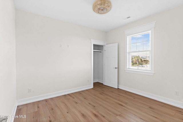 unfurnished bedroom featuring visible vents, light wood finished floors, and baseboards