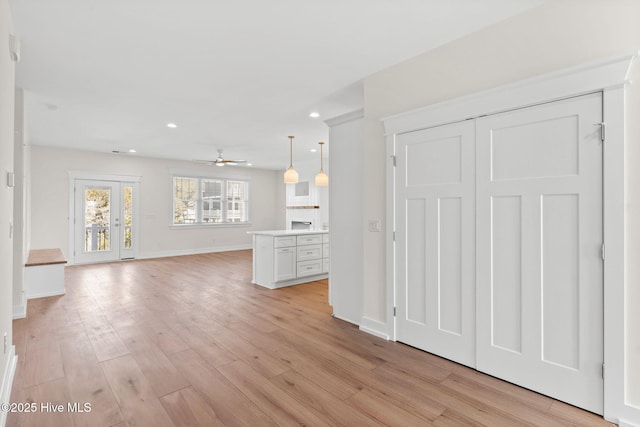 unfurnished living room with light wood finished floors, baseboards, a ceiling fan, and recessed lighting