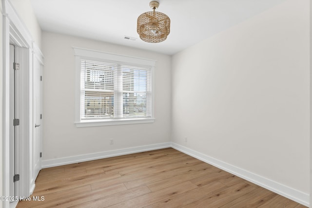 unfurnished bedroom featuring light wood finished floors, visible vents, and baseboards