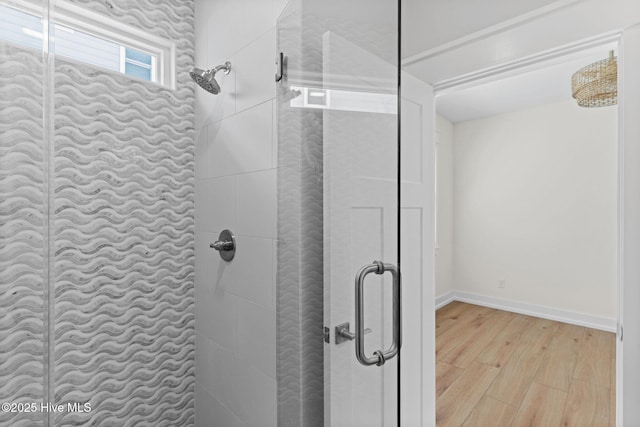 bathroom featuring a stall shower, wood finished floors, and baseboards