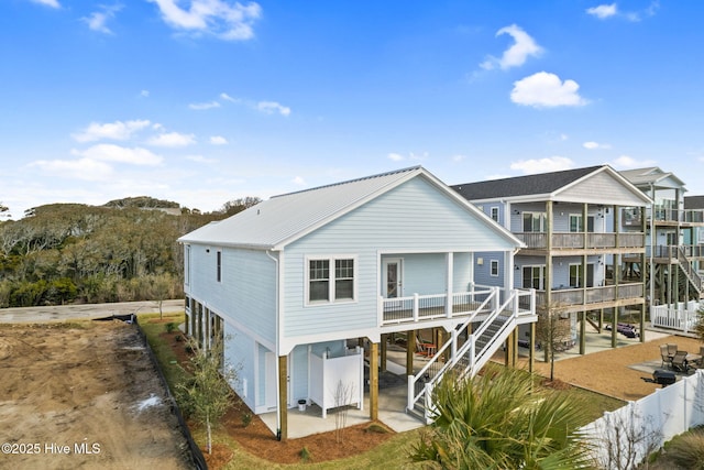 back of property featuring a patio, fence, a carport, driveway, and stairs