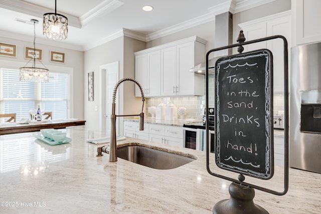 kitchen with white cabinets, decorative backsplash, stainless steel fridge with ice dispenser, ornamental molding, and a sink