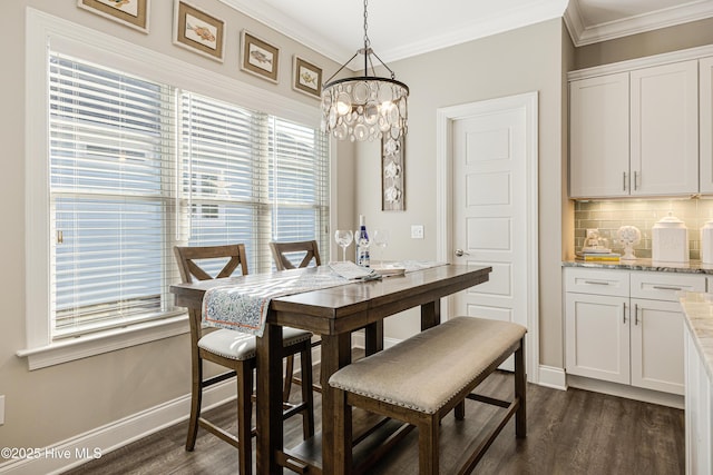 dining room with ornamental molding, dark wood-type flooring, an inviting chandelier, and baseboards