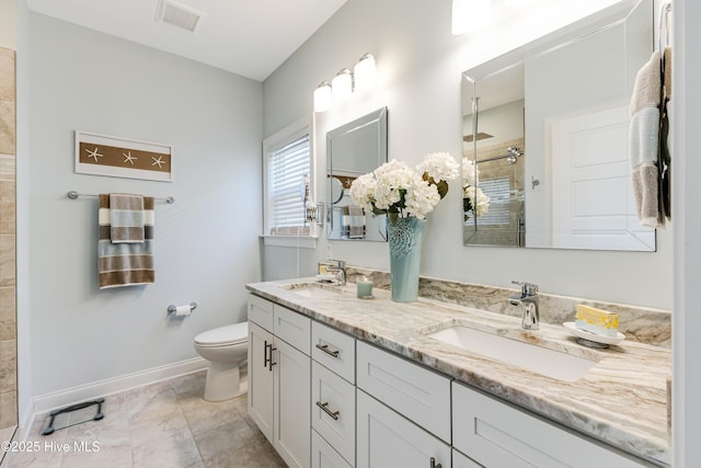 full bath featuring visible vents, a sink, a tile shower, and toilet