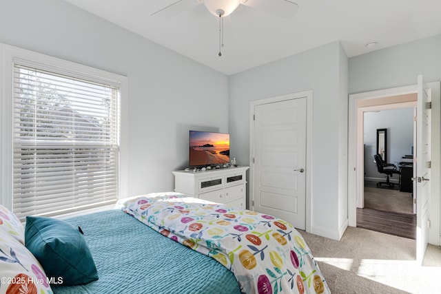 bedroom featuring light carpet, ceiling fan, and baseboards