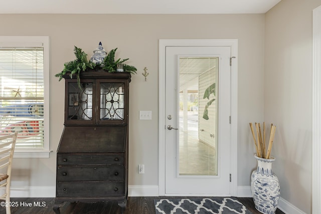 doorway to outside featuring wood finished floors and baseboards