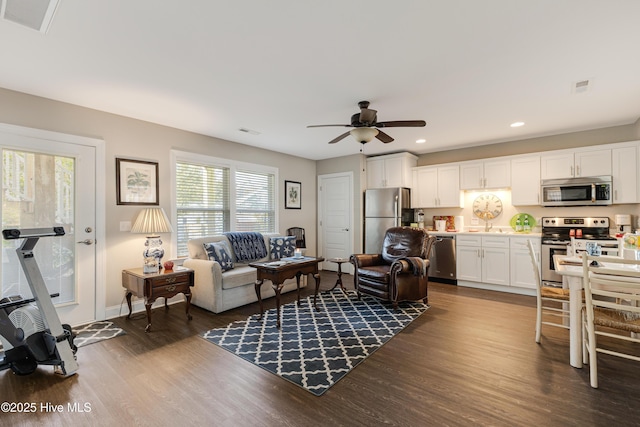 living room with dark wood-type flooring, recessed lighting, visible vents, and ceiling fan