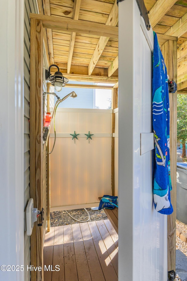 bathroom with hardwood / wood-style floors, beamed ceiling, and wooden ceiling