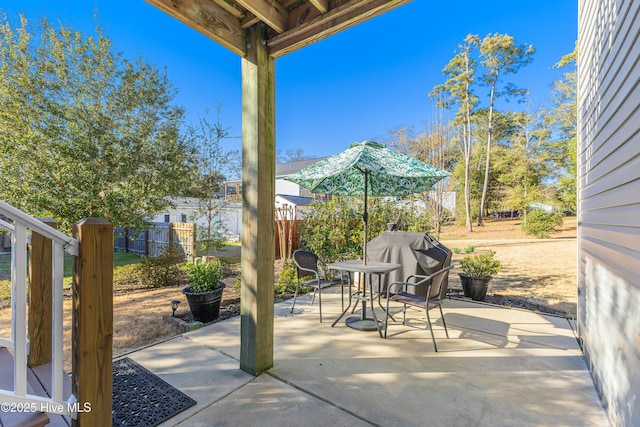 view of patio / terrace with a grill, fence, and outdoor dining space