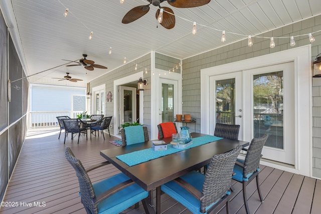 wooden terrace featuring outdoor dining area, a ceiling fan, and french doors