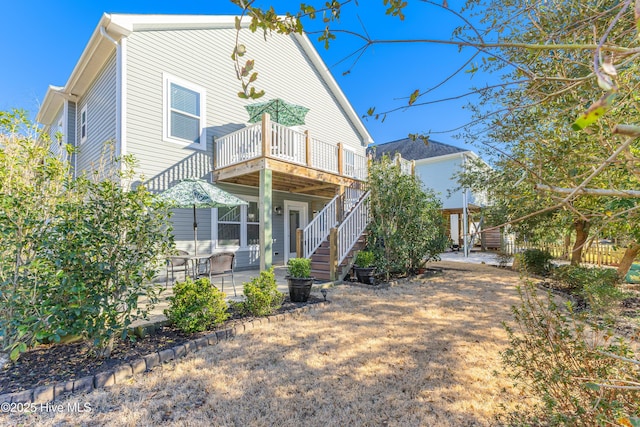 back of house with stairs, a patio, and a wooden deck