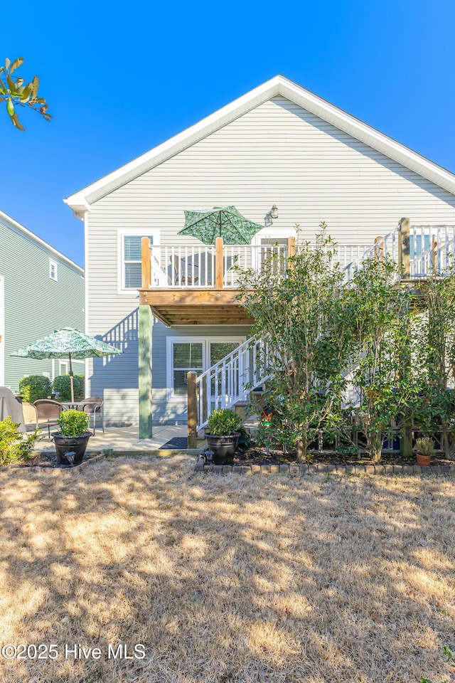 rear view of house featuring a patio and stairway