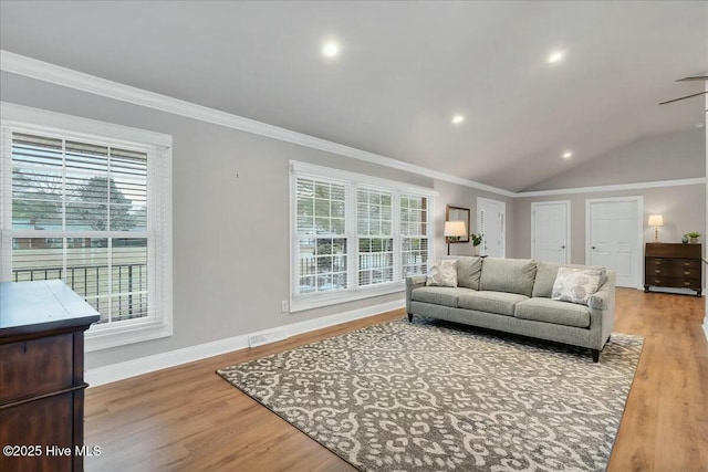 living room featuring light wood finished floors, vaulted ceiling, baseboards, and ornamental molding