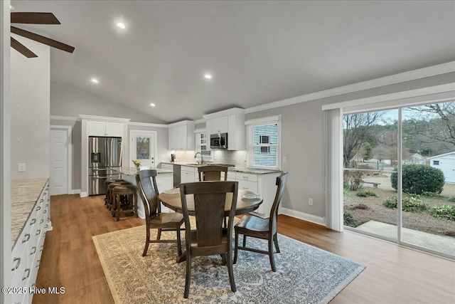 dining room featuring recessed lighting, light wood-style flooring, baseboards, and vaulted ceiling