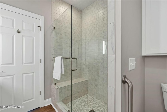 bathroom with toilet and a stall shower