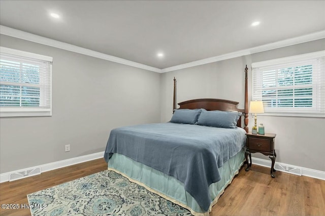 bedroom featuring visible vents, baseboards, and wood finished floors