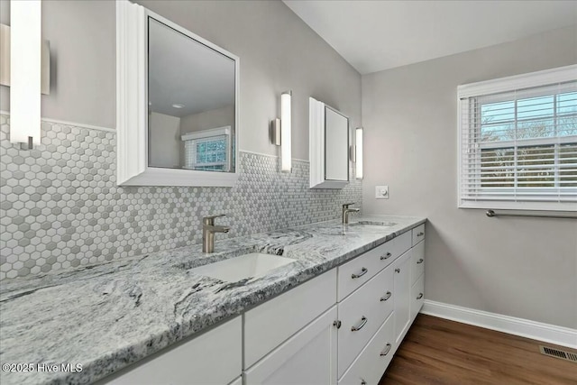 full bathroom featuring decorative backsplash, double vanity, visible vents, and a sink