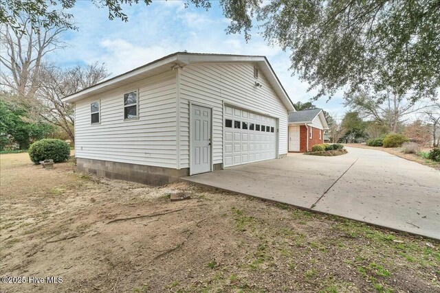 view of side of home featuring a garage and driveway