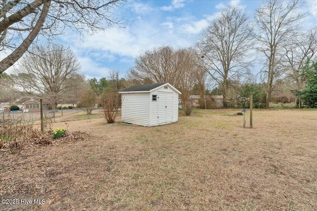 view of yard with fence, an outdoor structure, and a shed