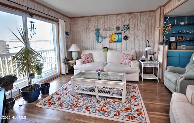 living room with wood finished floors and crown molding