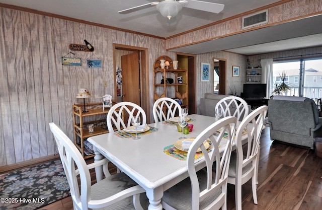 dining area featuring crown molding, visible vents, ceiling fan, baseboards, and hardwood / wood-style flooring