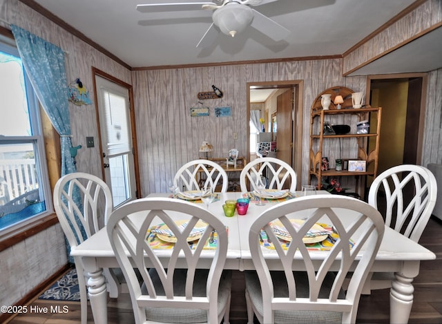 dining space featuring wallpapered walls, ornamental molding, a ceiling fan, and a healthy amount of sunlight