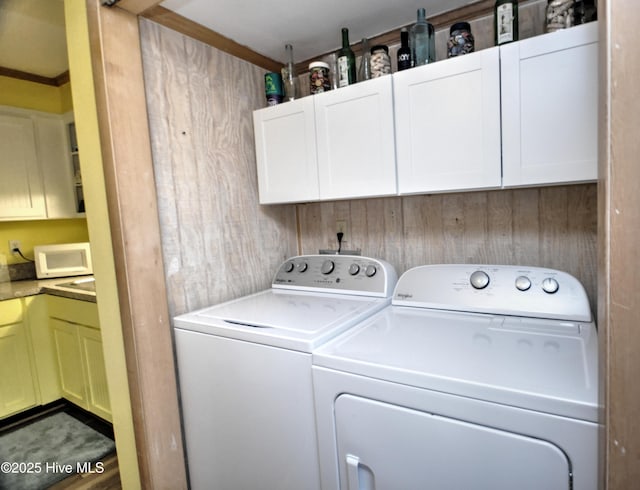 washroom with washing machine and dryer and cabinet space