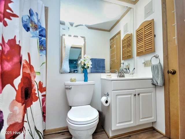 full bath with toilet, a shower with curtain, wood finished floors, and vanity