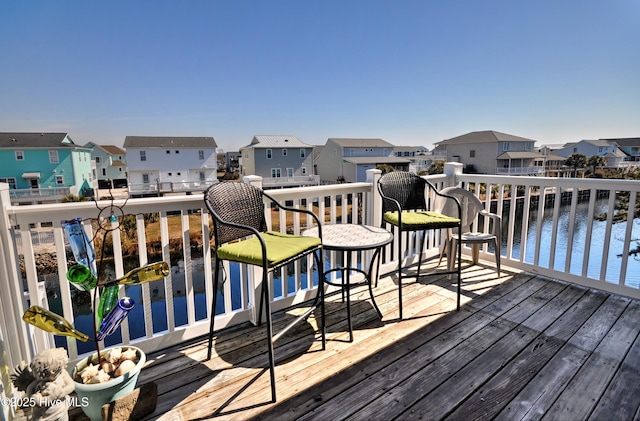 wooden terrace featuring a water view and a residential view