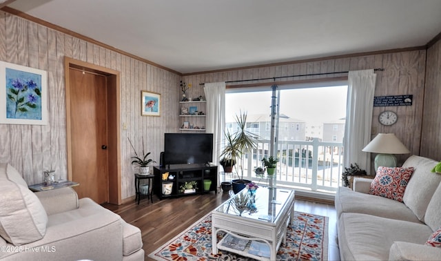 living room with wood finished floors and crown molding