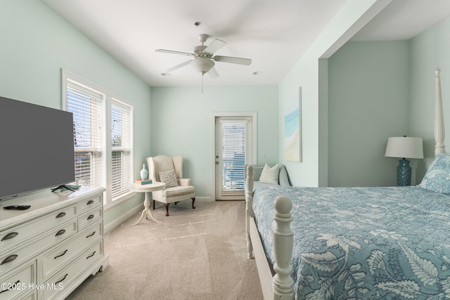 bedroom featuring light carpet, a ceiling fan, and baseboards