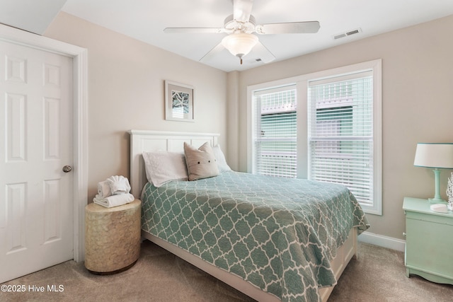 carpeted bedroom featuring baseboards, visible vents, and a ceiling fan