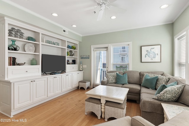 living room with ornamental molding, visible vents, ceiling fan, and light wood finished floors