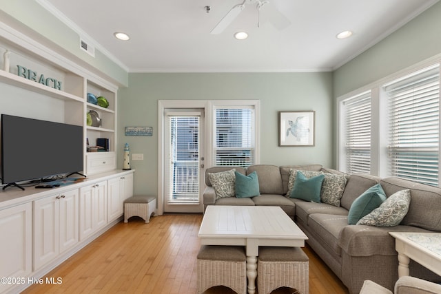 living area featuring ceiling fan, light wood-type flooring, visible vents, and crown molding