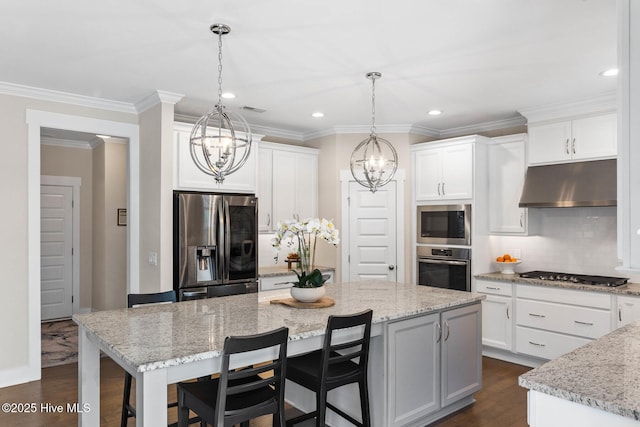 935 Baldwin Park Dr, Wilmington, NC 28411 - kitchen with appliances with stainless steel finishes, under cabinet range hood, a chandelier, tasteful backsplash, and white cabinetry