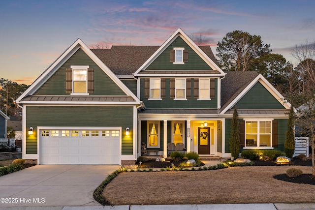 craftsman inspired home with a garage, driveway, a standing seam roof, and covered porch