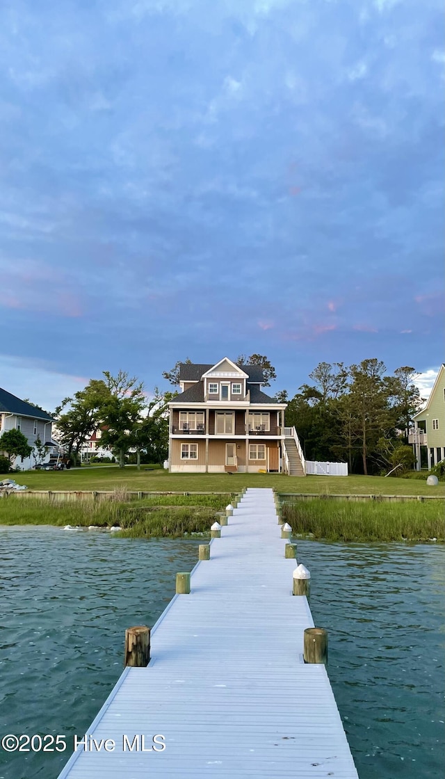 view of dock featuring a water view and a lawn