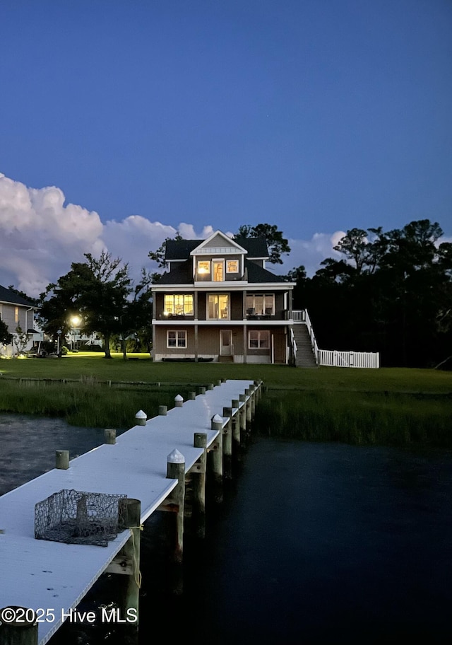 dock area featuring a water view, a yard, a balcony, and fence