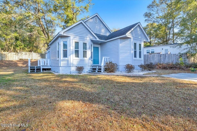 bungalow-style house with fence and a front yard